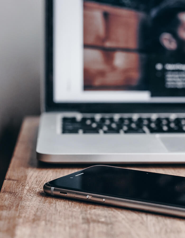 Un macbook aperto a un iphone su un tavolo